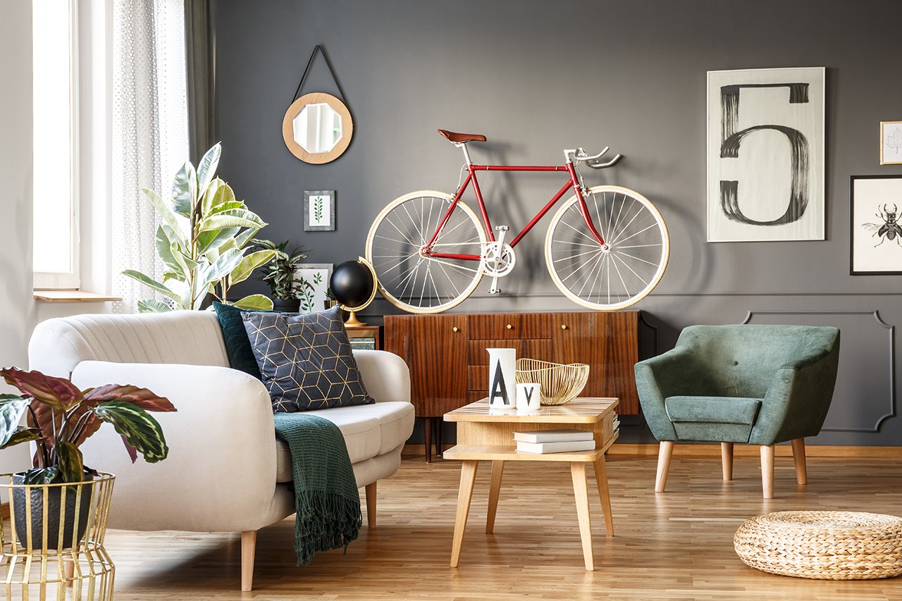 Vintage unique living room interior with good vibes with white comfortable sofa with cushions and blanket and green armchair,